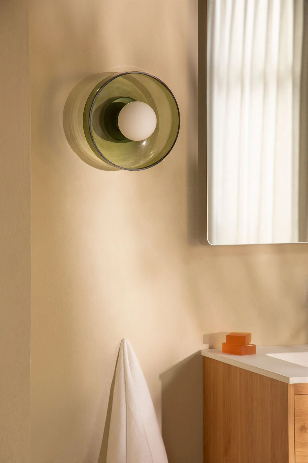 Iluminación natural y aplique decorativo en baño pequeño con ducha, tonos neutros que amplían el espacio visualmente