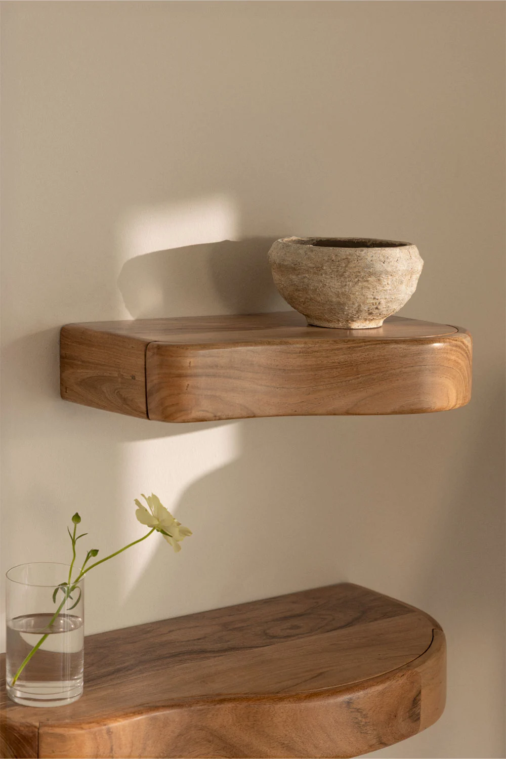 Mensole sospese in legno su una piccola terrazza chiusa: una soluzione di contenimento decorativa e funzionale per piccoli spazi.