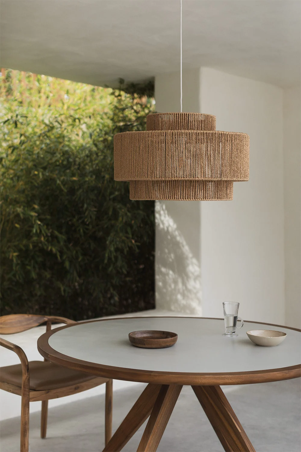 Lampada da soffitto in fibra naturale su una piccola terrazza chiusa, ideale per un'illuminazione ambientale calda e decorativa in spazi ridotti.