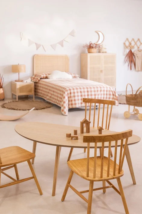 Habitación infantil para niña o niño de 8 años con cama de mimbre, zona de estudio y decoración cálida en tonos tierra