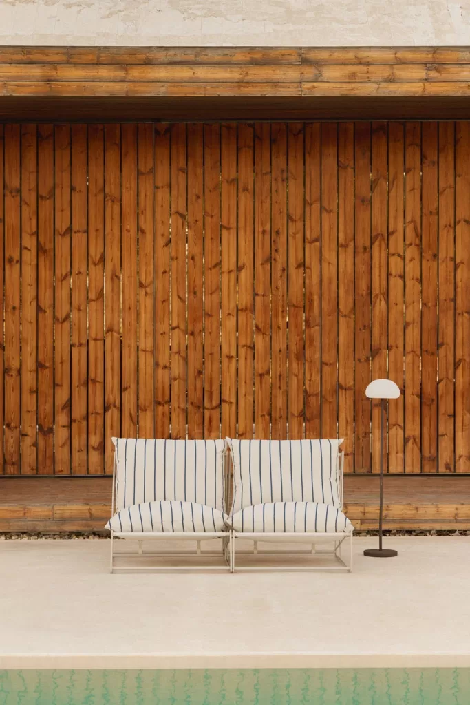 Sofás de exterior con cojines a rayas y lámpara decorativa, una idea para terraza tipo chill-out que invita al descanso total.