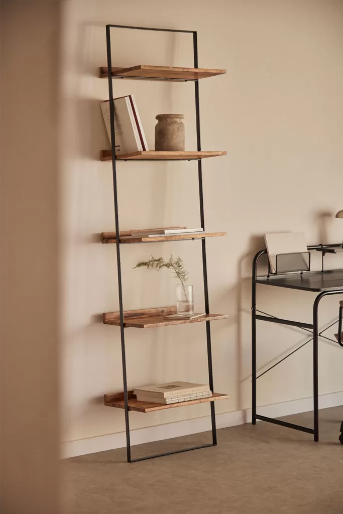 Étagère de style échelle avec un cadre en métal noir et des étagères en bois naturel décorées de céramique, de livres et de verre pour un décor d'étagère texturé.