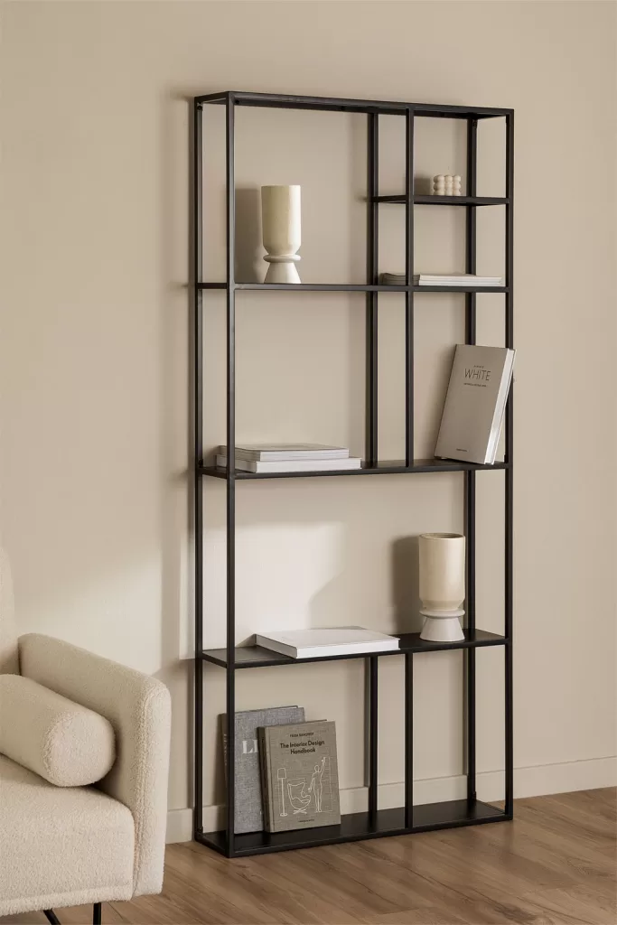 Étagères minimalistes en métal noir avec des vases et des livres en céramique soigneusement disposés, un exemple de décoration d'étagères privilégiant la qualité à la quantité