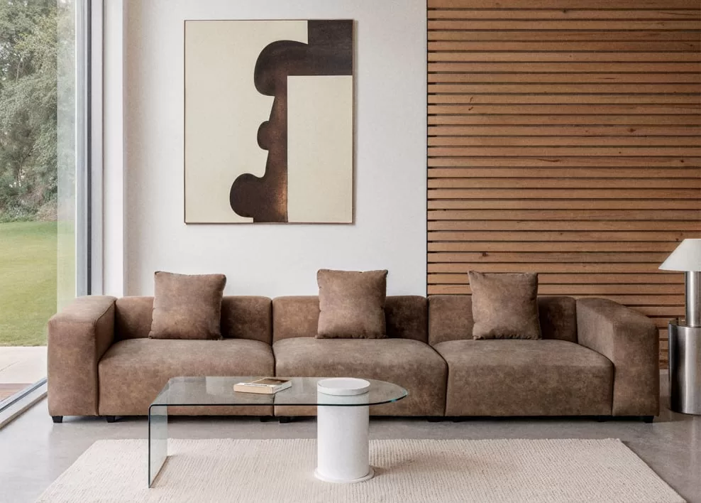 Großes abstraktes Gemälde über einem braunen Sofa in einem modernen Wohnzimmer, ein Beispiel für eine minimalistische Komposition von Gemälden über dem Sofa als Blickfang.