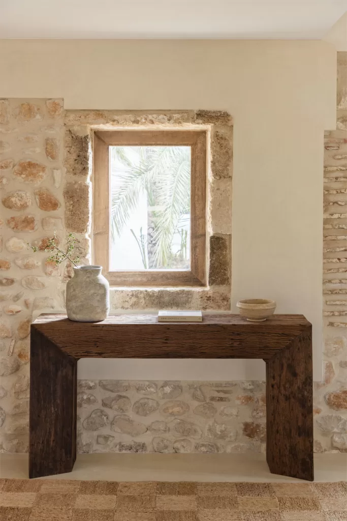 Consola de madera reciclada en decoración casa de pueblo con muros de piedra y estilo rústico moderno