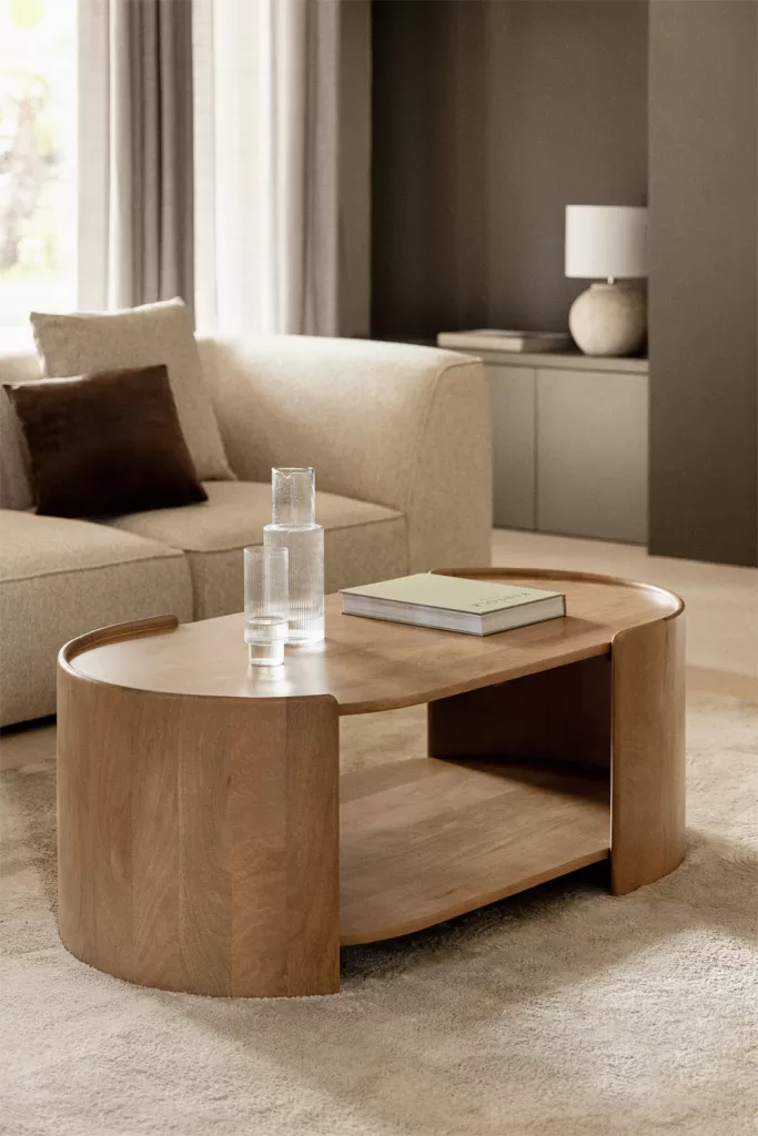 Decoração de sala de estar em cinza e bege com sofá claro e mesa de madeira natural, criando um ambiente aconchegante e elegante.