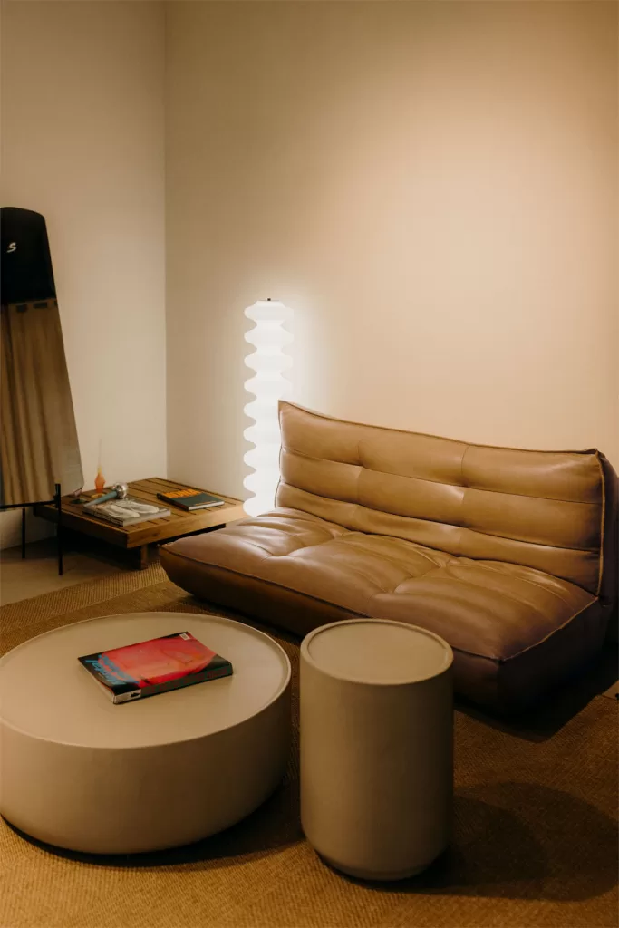 Sofá reclinable de 2 plazas en polipiel marrón con mesa de centro redonda en salón moderno, ejemplo de cómo elegir un sofá adecuado según el espacio y la decoración