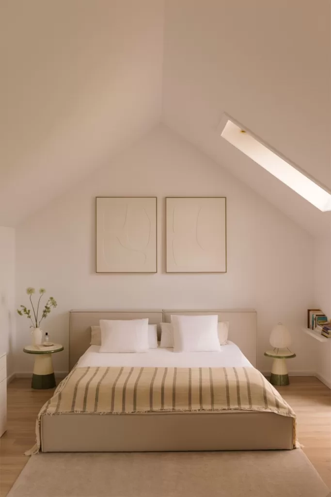 Quarto com cama baixa minimalista para aproveitar um sótão muito baixo e criar uma sensação de amplitude.