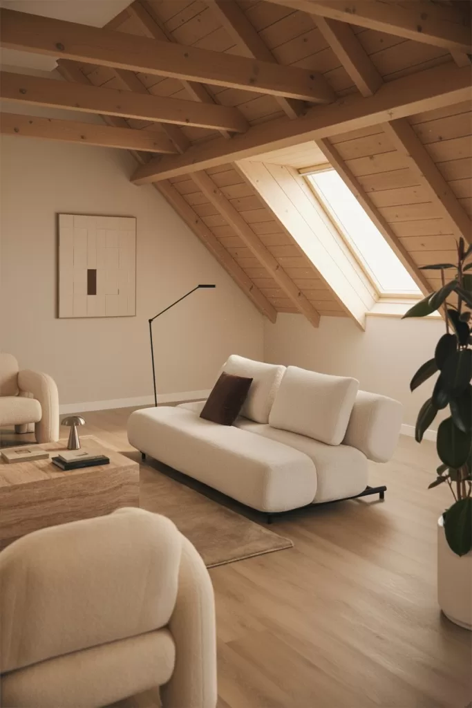 Decoração com tecidos leves e um sofá baixo para aproveitar um sótão muito baixo e criar amplitude visual.