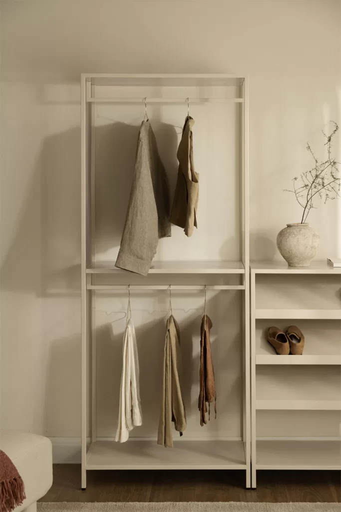 Minimalistischer offener Schrank in einem kleinen Schlafzimmer für Paare mit Kleiderschrank, der visuelle Leichtigkeit und Weite schafft
