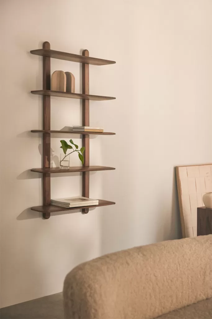 Étagères et petits meubles en bois clair ajoutant une chaleur naturelle à une chambre verte et grise