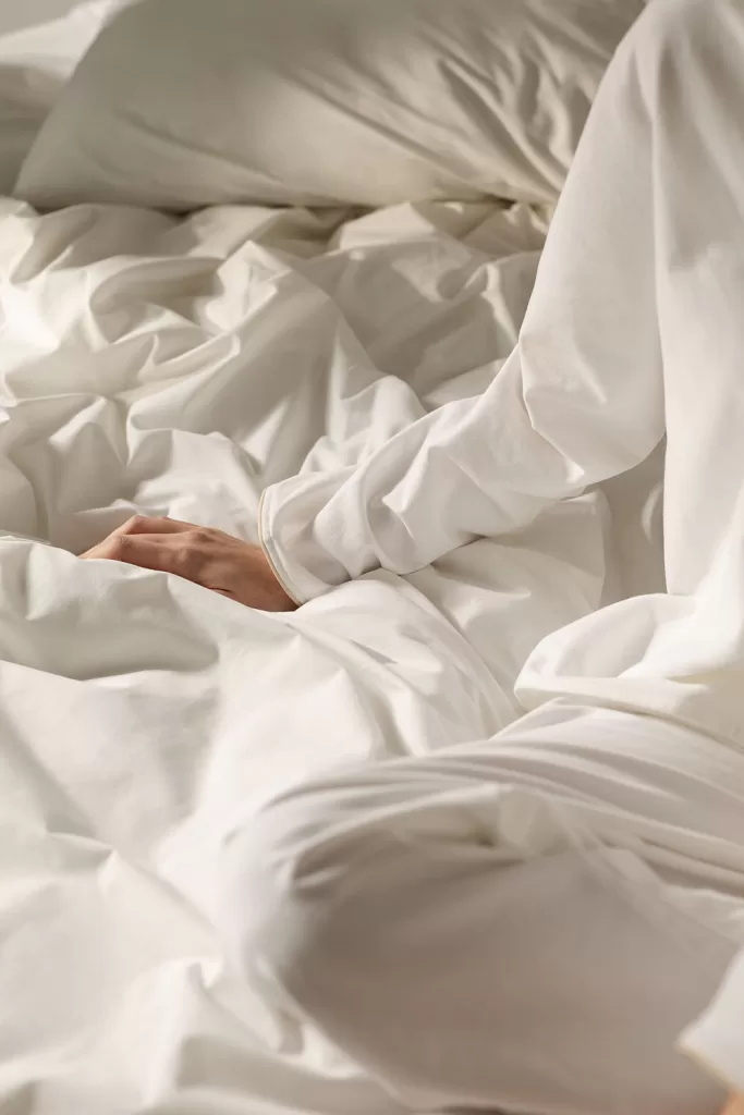 Ropa de cama blanca que ilumina y aporta frescura en un dormitorio gris y blanco moderno