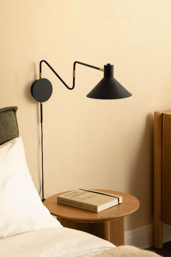 Applique murale en noir mat et laiton, accent décoratif moderne dans une chambre verte et grise