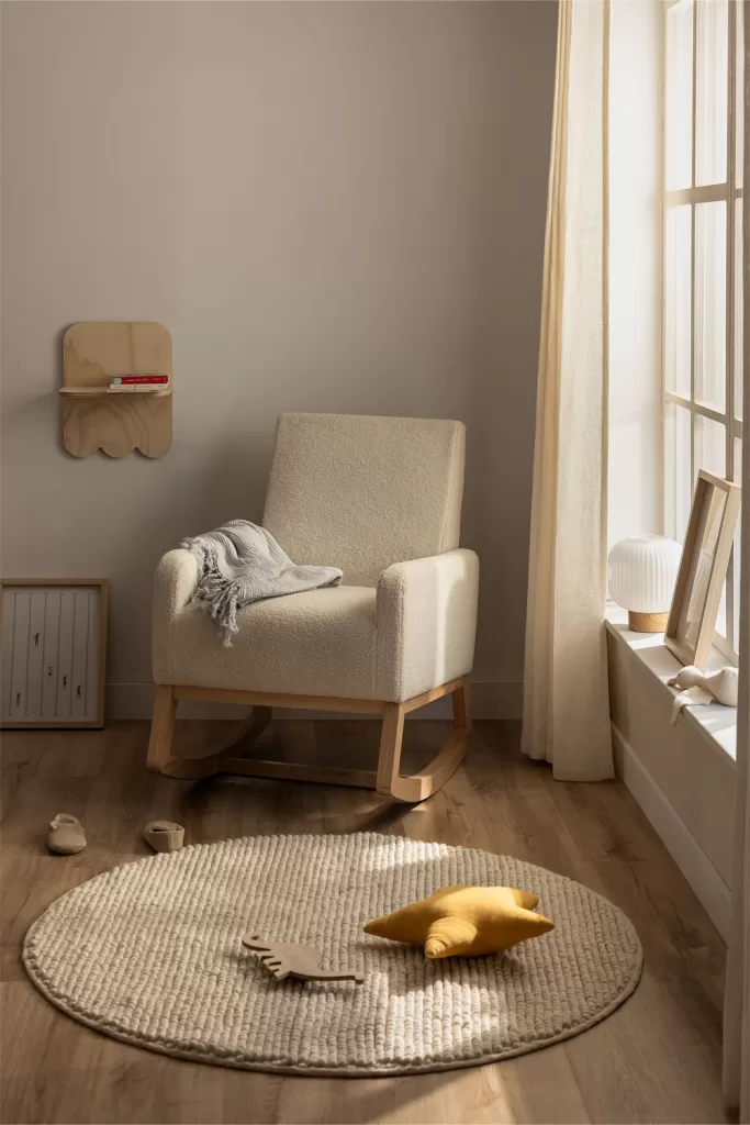 Coin cosy avec fauteuil et couverture dans la décoration de la chambre de bébé