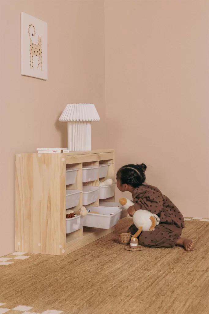 Décoration naturelle dans une chambre de bébé avec une étagère en bois et une enfant qui joue
