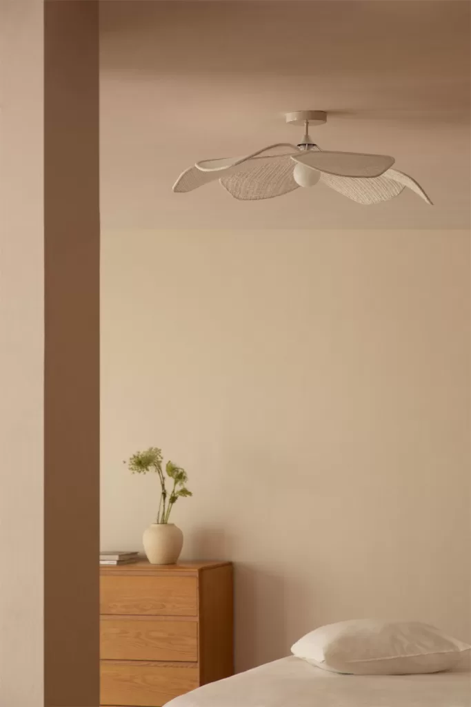Iluminación en capas con lámpara de techo y mesita de noche en un dormitorio gris y blanco minimalista