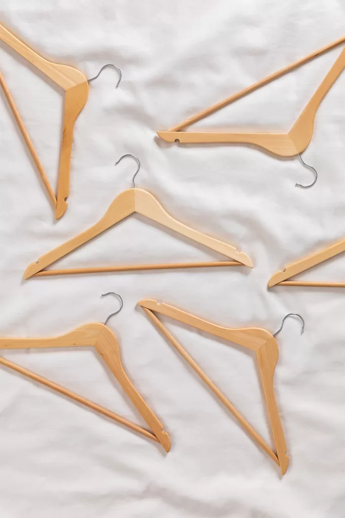 Geordnete Holzbügel zur Optimierung des Platzes in einem kleinen Schlafzimmer für Paare mit offenem Kleiderschrank