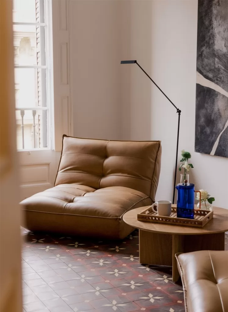 Esquina de lectura con butaca y mesa auxiliar con prensa francesa; decorar un rincón para el café acogedor