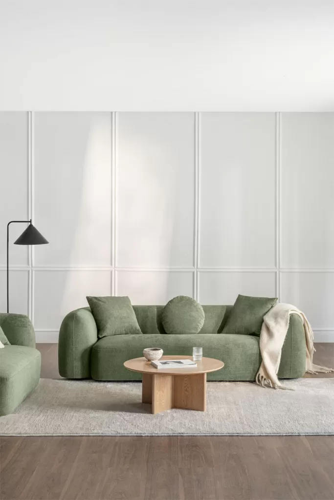 So kombinieren Sie ein grünes Sofa mit weißen Wänden und einem Couchtisch in neutralen Tönen