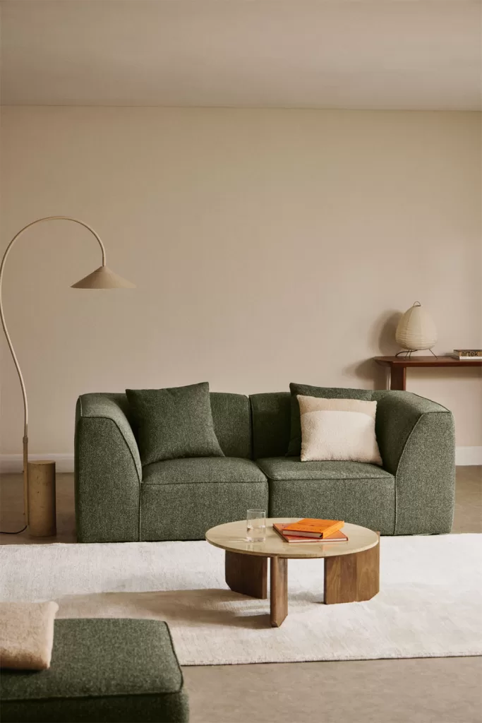 So kombinieren Sie ein grünes Sofa mit beigen Wänden und minimalistischem Dekor, um den Kontrast hervorzuheben, ohne den Raum zu überladen.