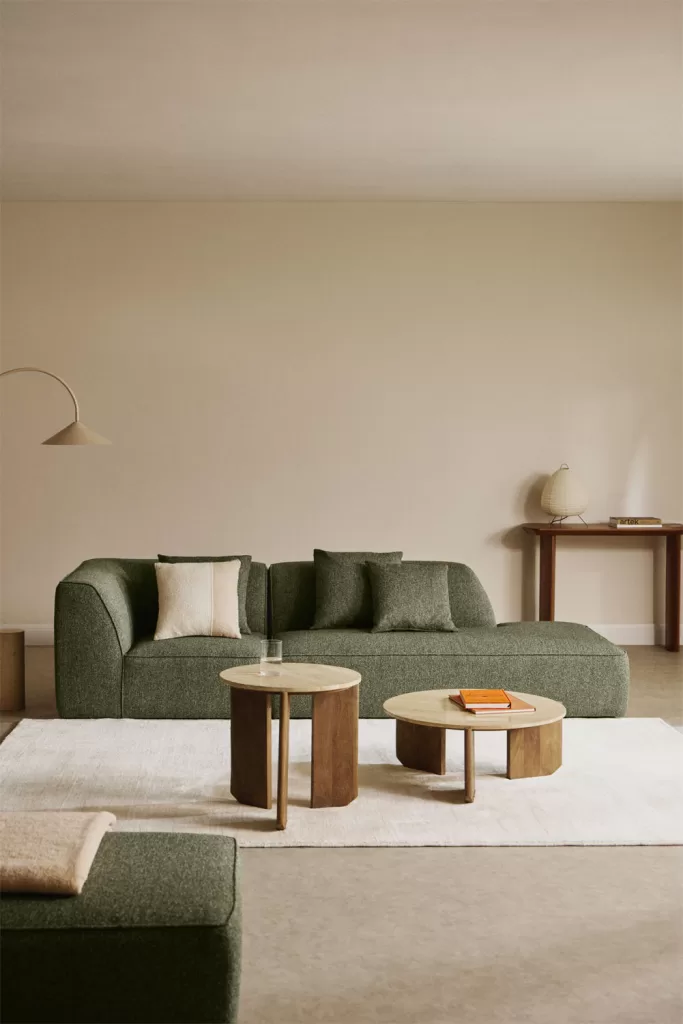So kombinieren Sie ein grünes Sofa mit Naturholzmöbeln im nordischen Stil, um ein gemütliches und organisches Wohnzimmer zu schaffen.