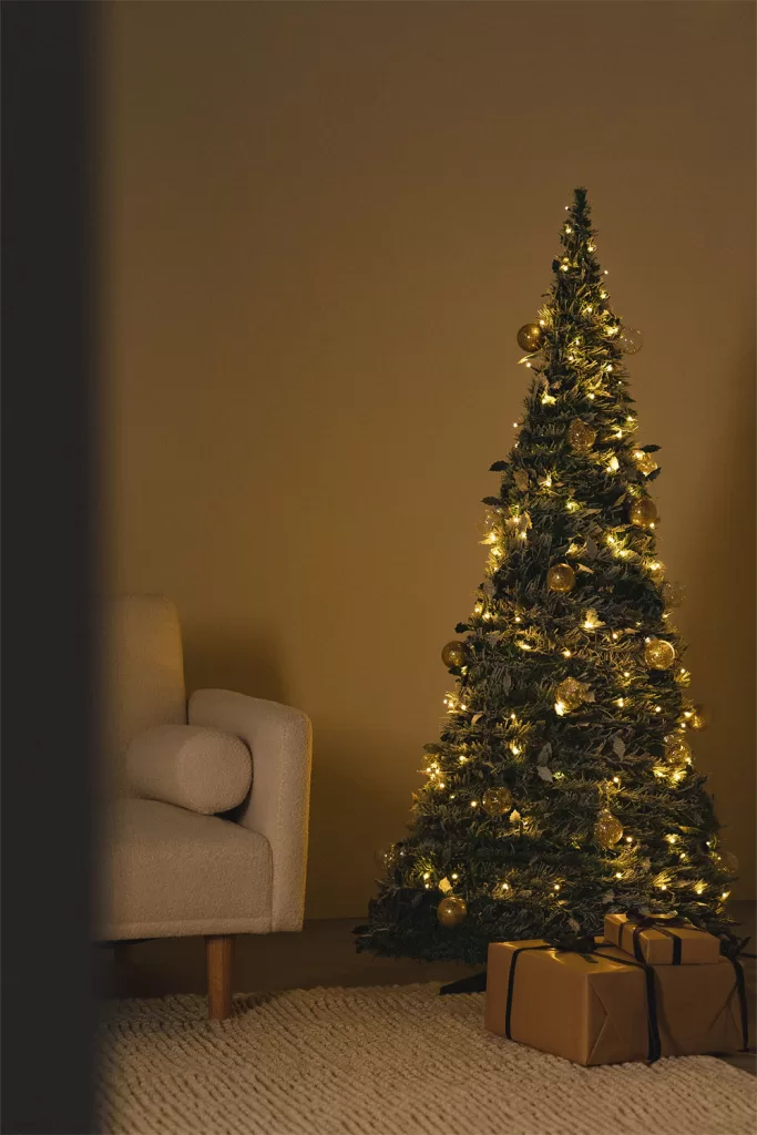 Luzes de Natal de tom quente a criar um ambiente acolhedor e a dar amplitude a uma sala pequena.