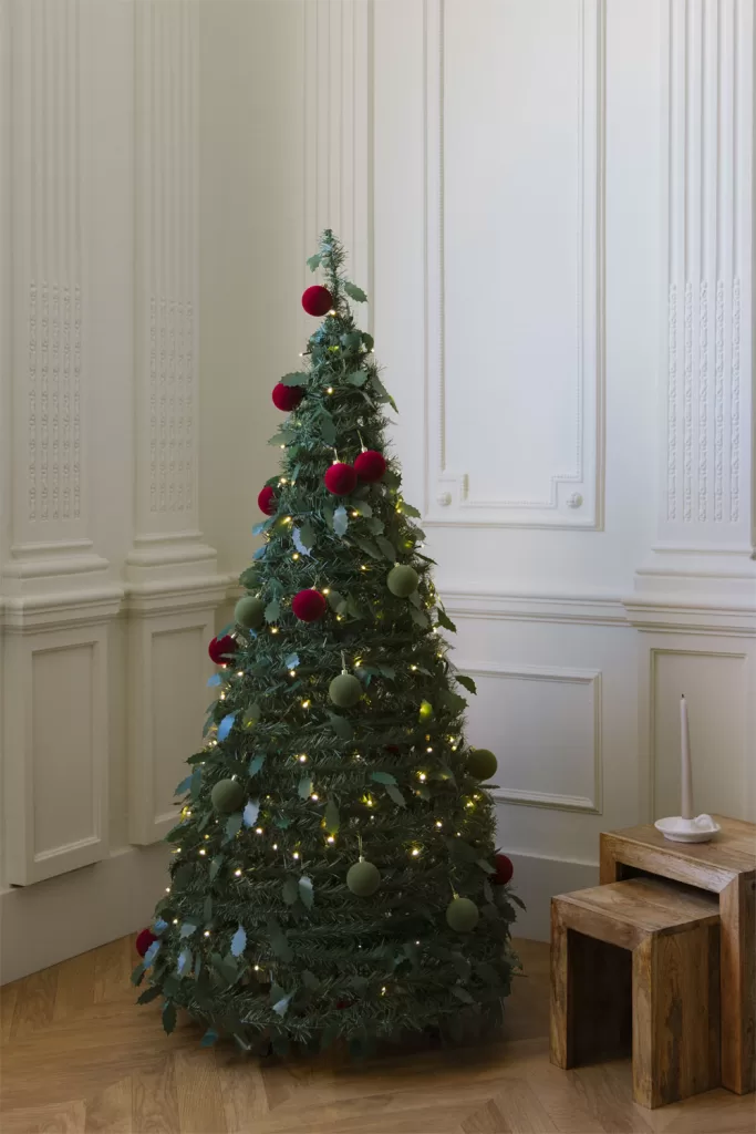 Árvore de Natal estilizada e alta, ideal para aproveitar o espaço vertical numa sala pequena.