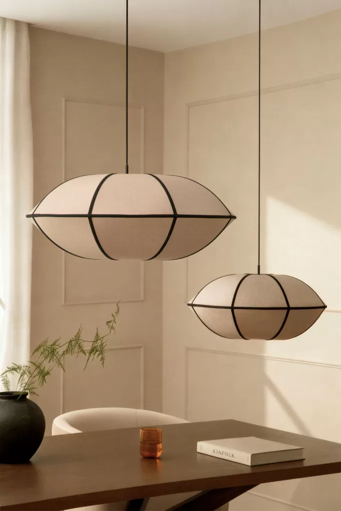 Dois candeeiros de teto pendentes em linho, a funcionar como peças esculturais e centrais na decoração do quarto.