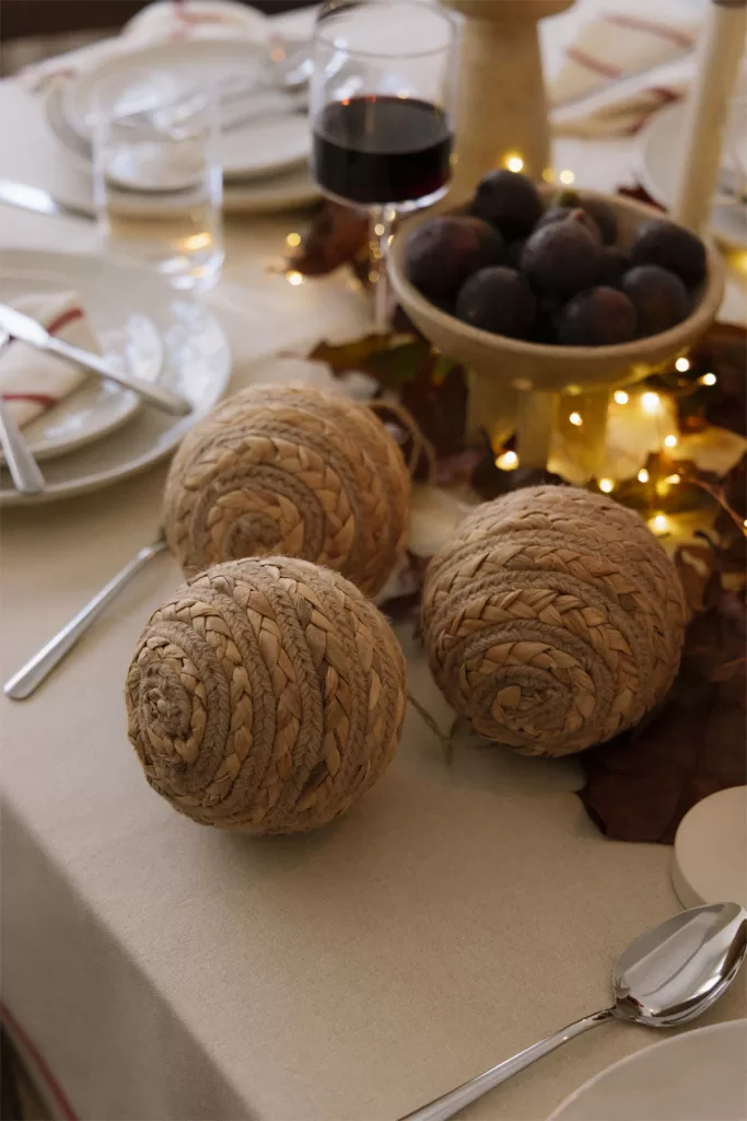 Mesa de centro com enfeites de Natal naturais e velas, uma alternativa à árvore tradicional em salas pequenas.