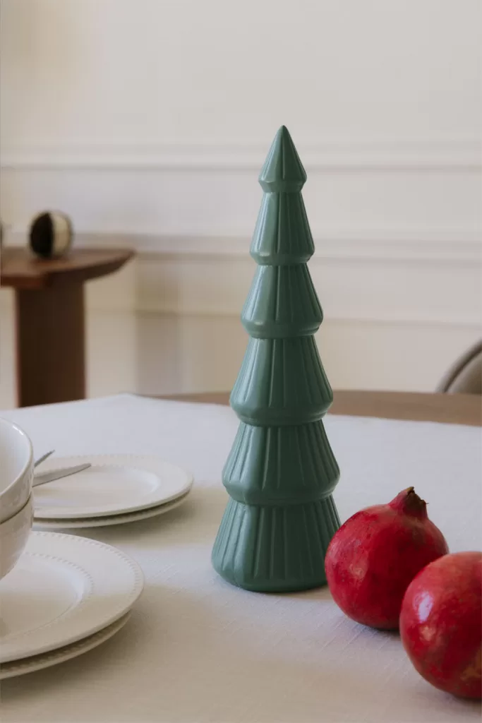 Sapin décoratif en céramique dans les tons verts comme idée minimaliste pour un centre de table de Noël moderne.