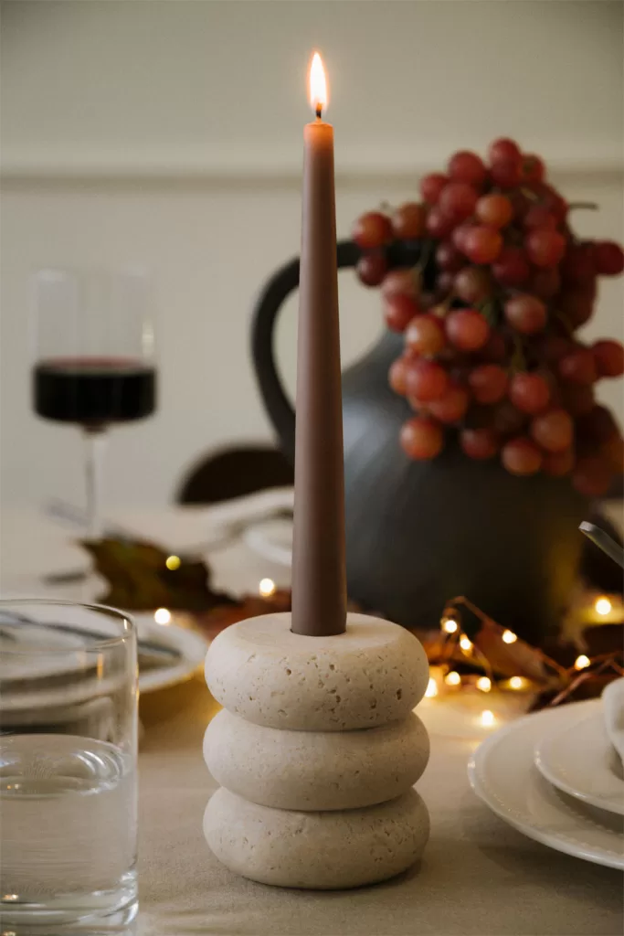 Bougeoir en pierre avec grande bougie comme idée de centre de table de Noël chaleureux et accueillant.