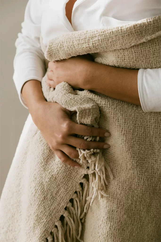 Plaid texturé posé de manière décontractée sur le pied du lit