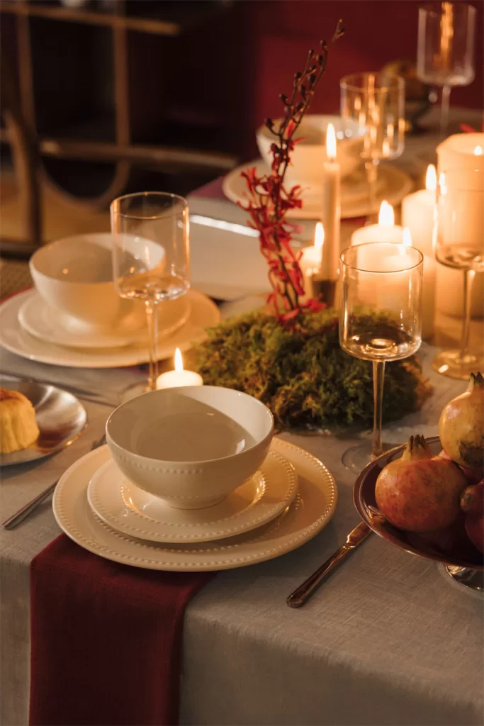 Centre de table de Noël avec nappe en lin lavé aux tons neutres et décoration naturelle pour une table de Noël élégante.