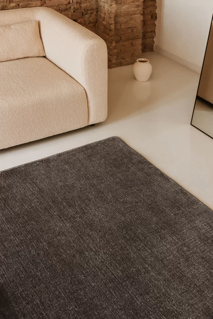 Estilo moderno con butaca bouclé crema y alfombra de pelo en tonos neutros, rincón minimalista con textura suave