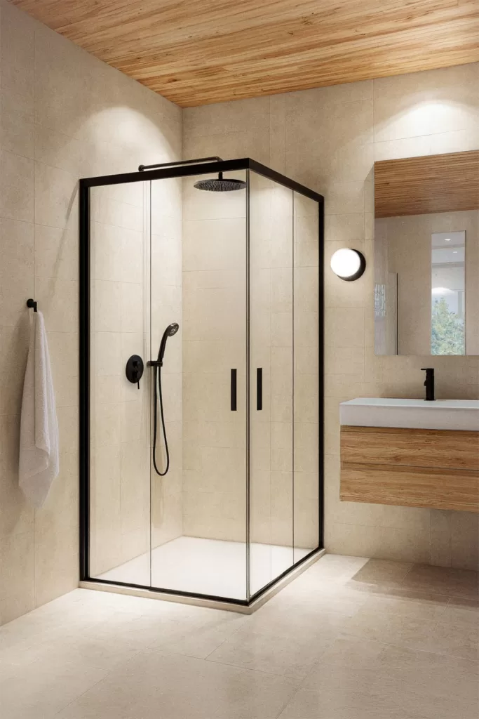 Paroi de douche d'angle avec portes coulissantes, verre transparent et profilés noirs dans une salle de bains contemporaine.