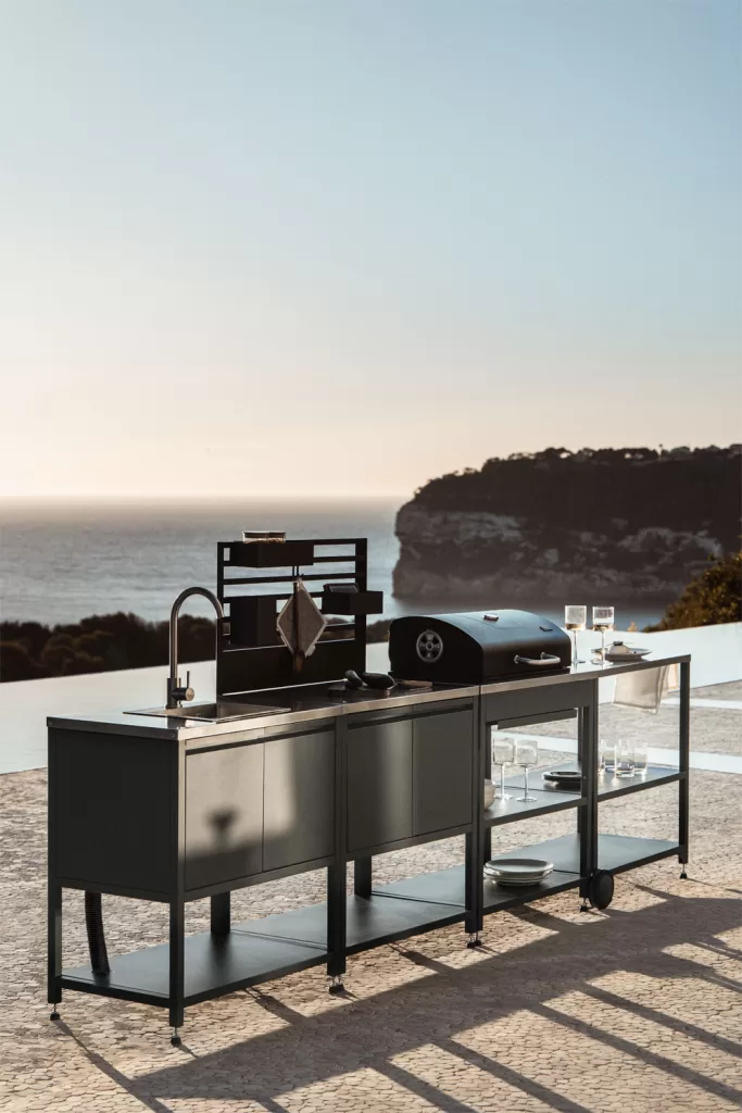 Módulo lineal de acero con fregadero y barbacoa en porche con cocina exterior frente al mar