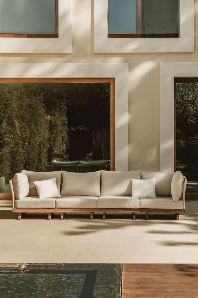 Jardines con piscina con sofá modular beige estilo lounge sobre terraza de piedra