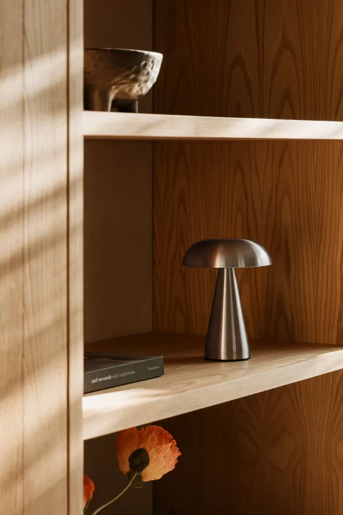 Lámpara metálica en balda de madera, propuesta de como decorar una vitrina de cristal con iluminación estratégica