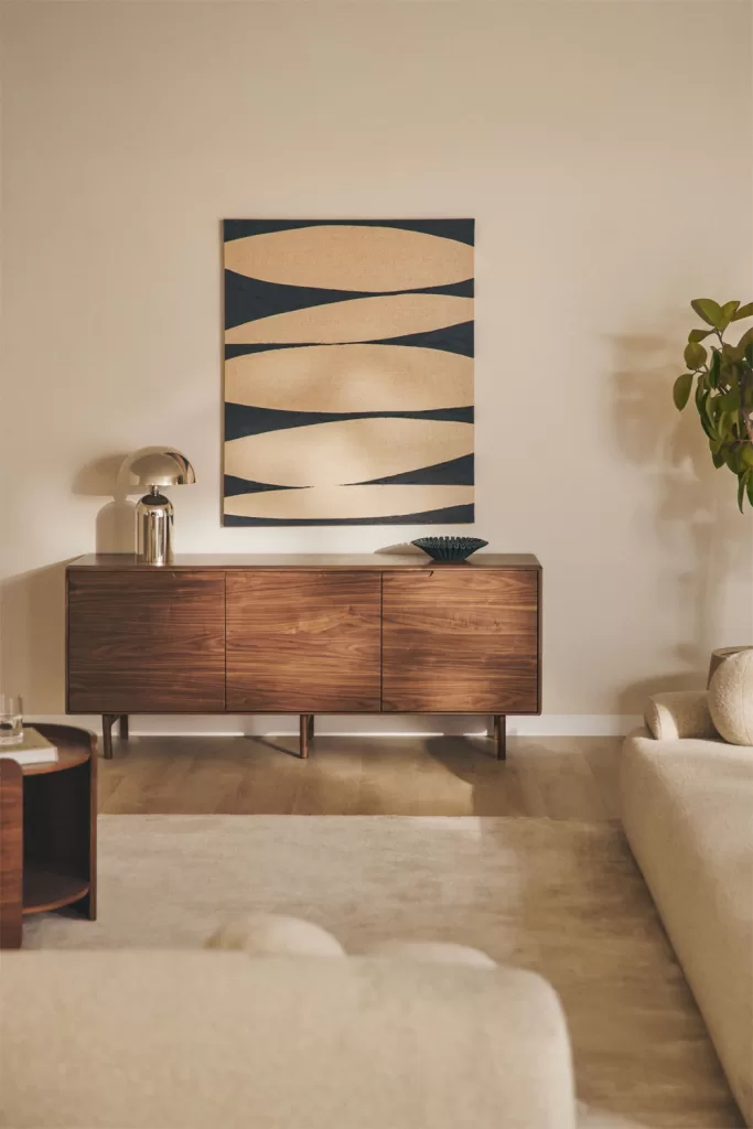 Como decorar um loft com aparador de madeira, candeeiro escultural e paleta quente numa sala neutra