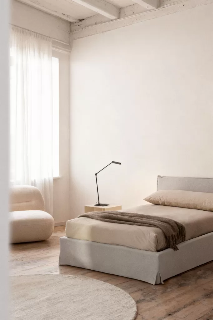 Cama nido beige para decorar estudio 20 metros con mobiliario abatible y textiles claros