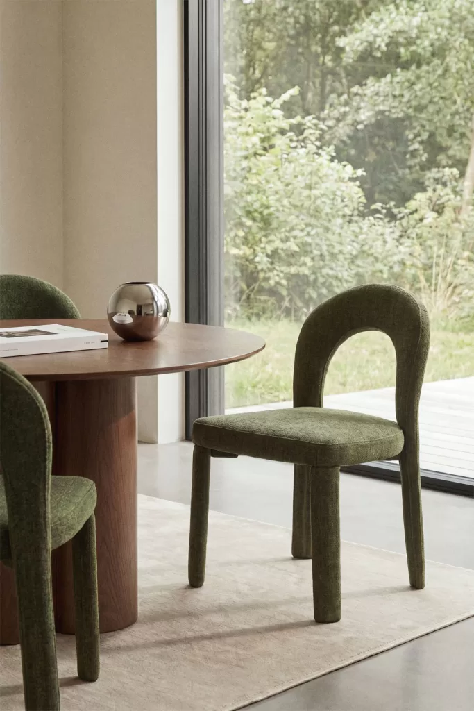Decorar cocina pequeña con silla verde tapizada, mesa redonda de madera y paleta cálida natural