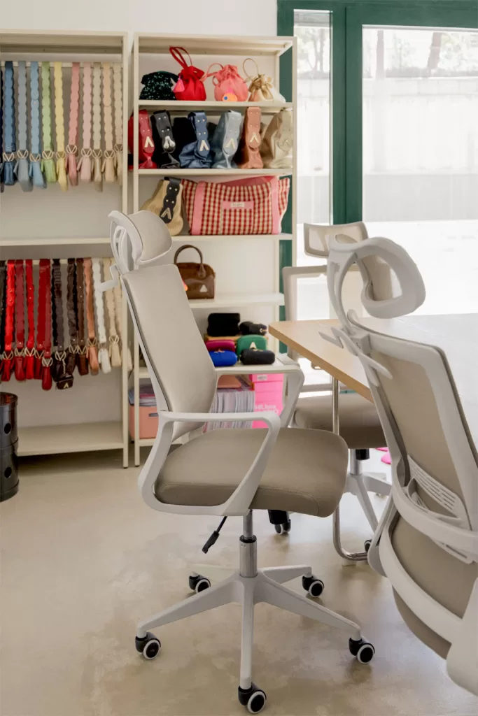 Silla ergonómica beige para postura correcta ordenador en escritorio blanco con ruedas y espacio de trabajo luminoso