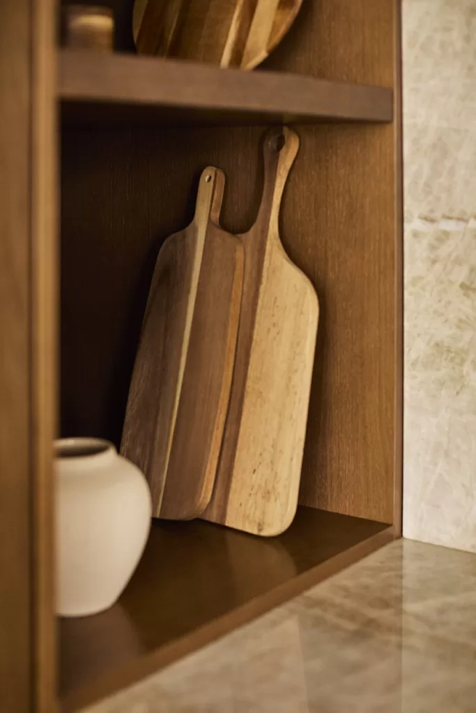 Decorar cocina pequeña con tablas de cortar de madera y utensilios integrados en estante abierto
