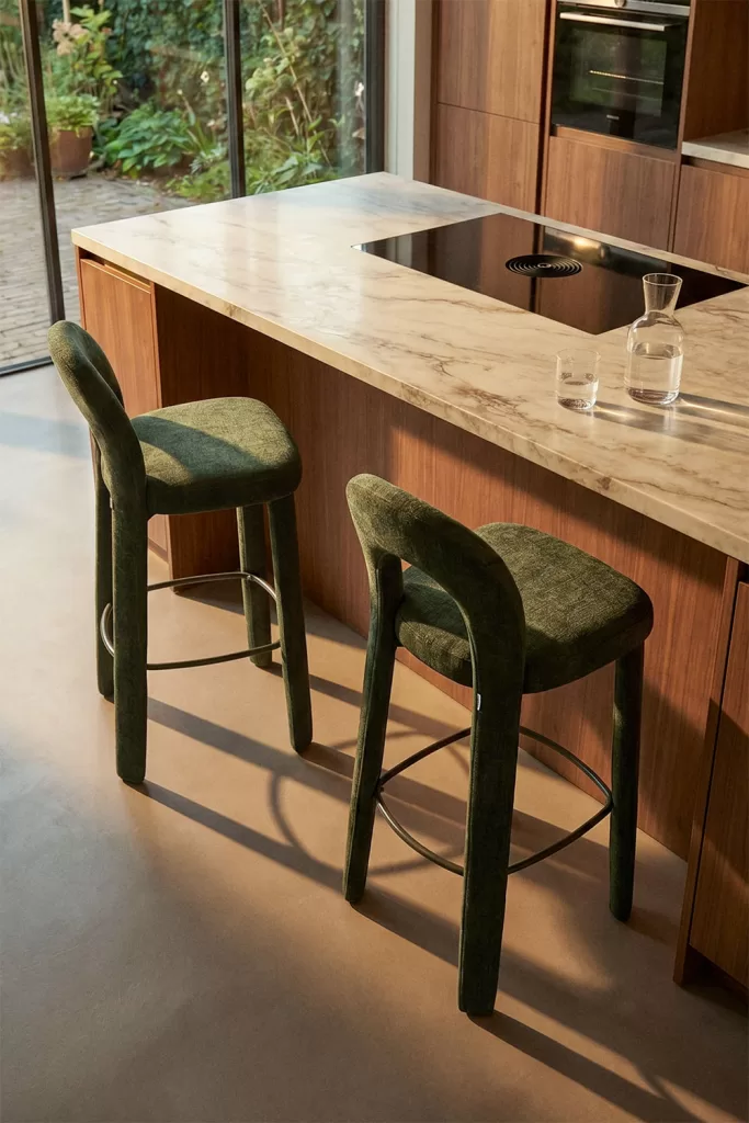 Decorar cocina pequeña con taburetes altos verdes junto a isla de mármol y madera en cocina compacta